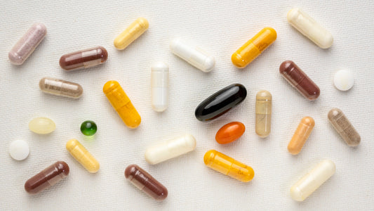 Different shaped supplements in multiple colors against a neutral textured background. Depicts the synergistic benefits of combining nutrients and the Benefits of Taking Magnesium and Vitamin B6