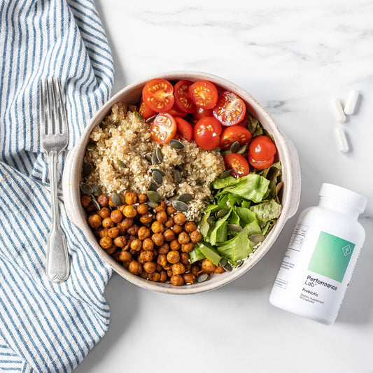 Buddha bowl with chickpeas, tomatoes, quinoa and salad and prebiotic capsules on the side