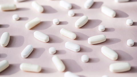 Magnesium and Melatonin Interaction: Can You Take Them Together? White pills of different sizes are laid in a grid formation.