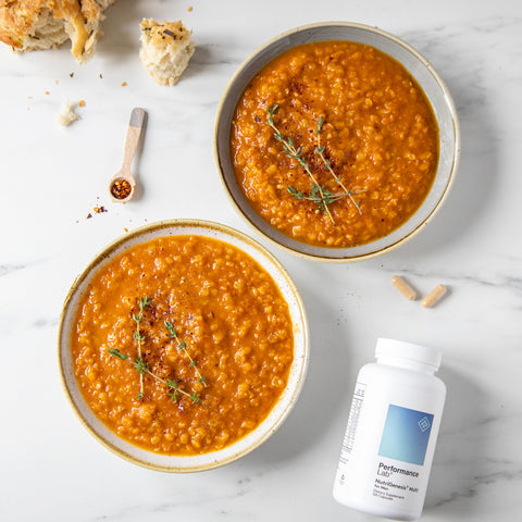 Two bowls of soup with bread and Performance Lab Nutrigenesis Multi for Men