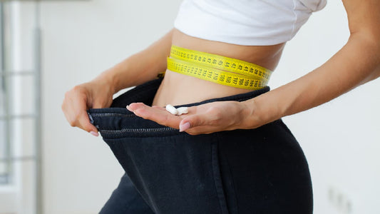 Woman in gym gear with a tape measure around her waist. Depicts someone taking magnesium for weight loss