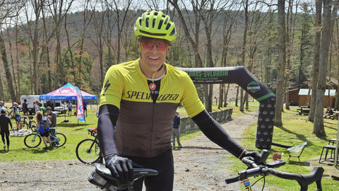 Performance Lab® customer John with his gravel bike at a cycling event, enjoying one of his favourite outdoor activities.