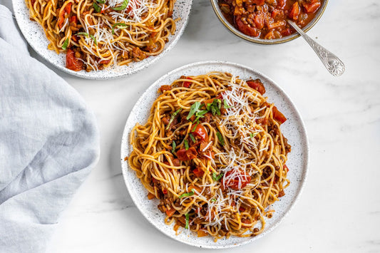 lentil bolognese plates with pasta, tomato sauce and cheese