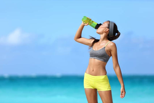 Can zinc help with weight loss? A woman drinks water on the beach after exercise