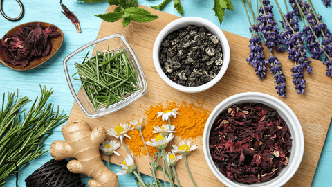 The best anti-inflammatories: herbs, spices, and natural supplements. verhead view of assorted herbs, spices, and tea on a wooden board.