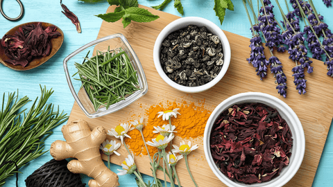 The best anti-inflammatories: herbs, spices, and natural supplements. verhead view of assorted herbs, spices, and tea on a wooden board.