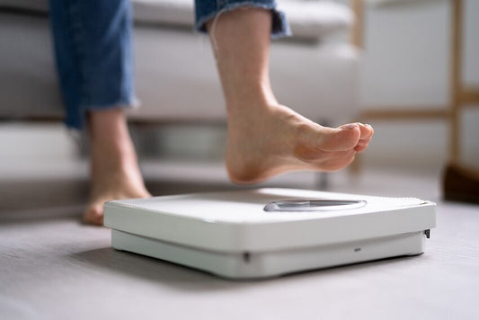 Does vitamin B12 cause weight gain? - woman standing on weighing scales