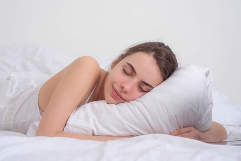 Does zinc help you sleep? A woman sleeps peacefully clutching a white pillow