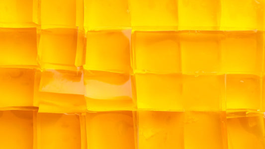 Gelatin versus collagen: which is better? Golden cubes of jelly arranged in a neat grid.