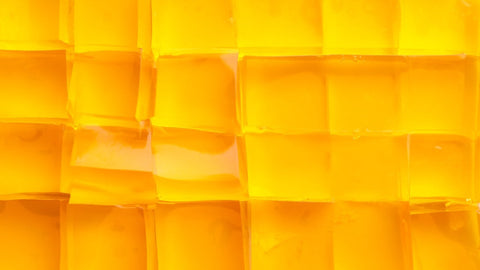 Gelatin versus collagen: which is better? Golden cubes of jelly arranged in a neat grid.