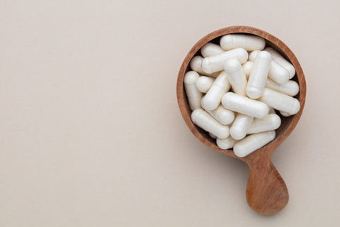 Best Vegetarian Glucosamine. White capsules of supplement in wooden bowl.