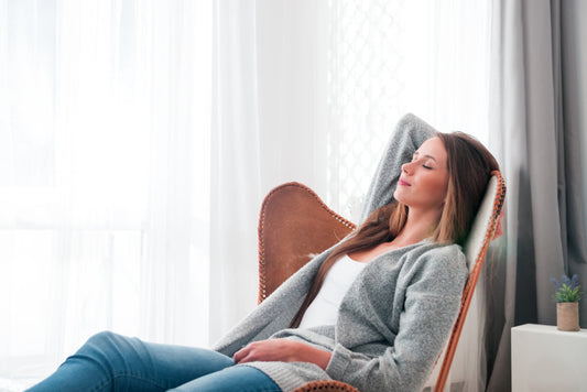 L-theanine and Lemon Balm: Your Best Allies for Relaxation and Sleep. A woman relaxes, comfortably reclined on a chair