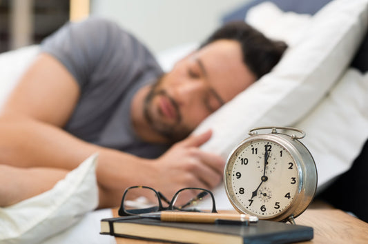 Lemon Balm and Sleep: A Natural Solution for Restful Nights? A man sleeps peacefully with an alarm clock on the bedside table